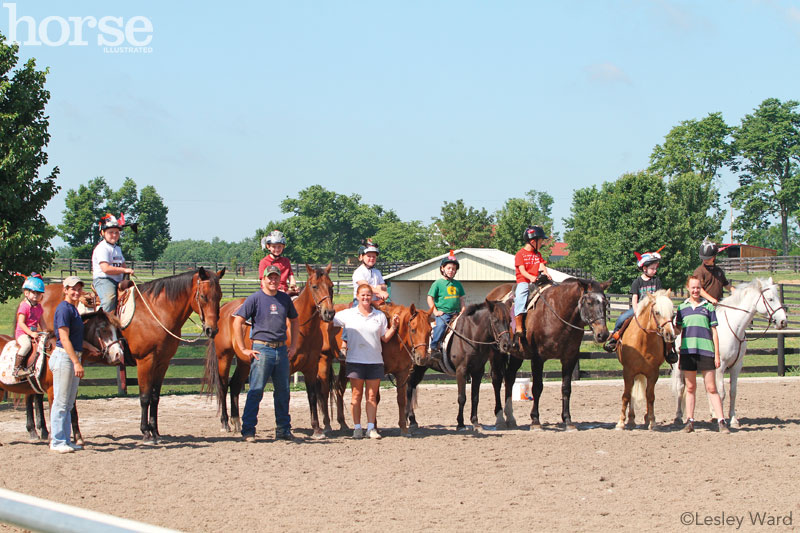 Group of campers, horses, and instructors at a summer horse camp