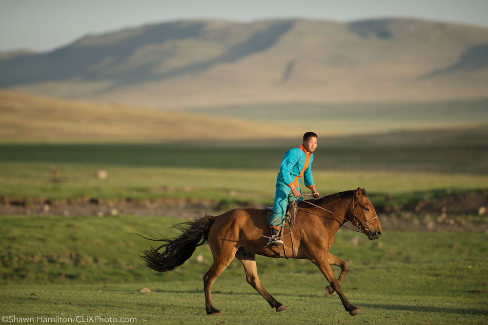 Young boy riding a horse in Mongolia