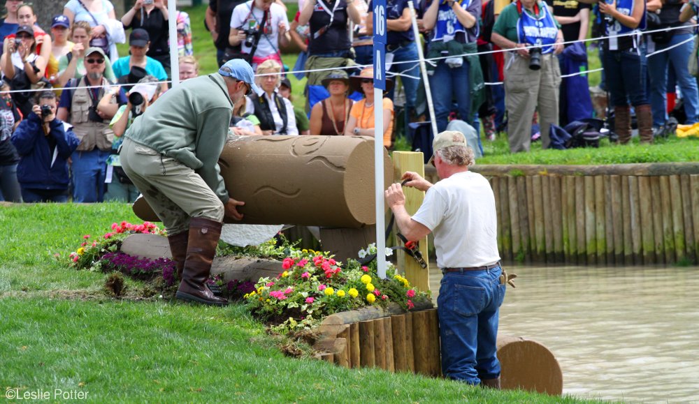 Jump crew in Dubarry boots replacing a foam log at a cross-country water jump