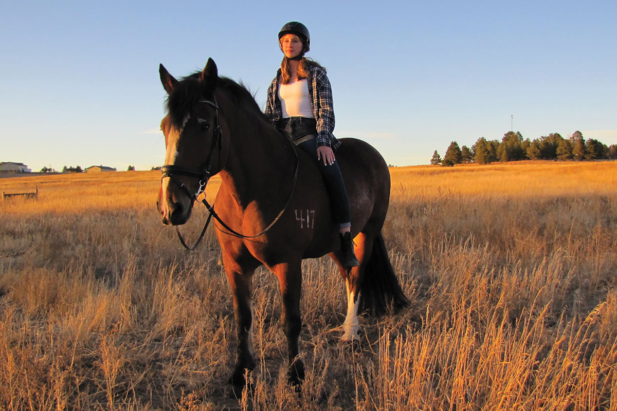 A girl sits bareback on her horse