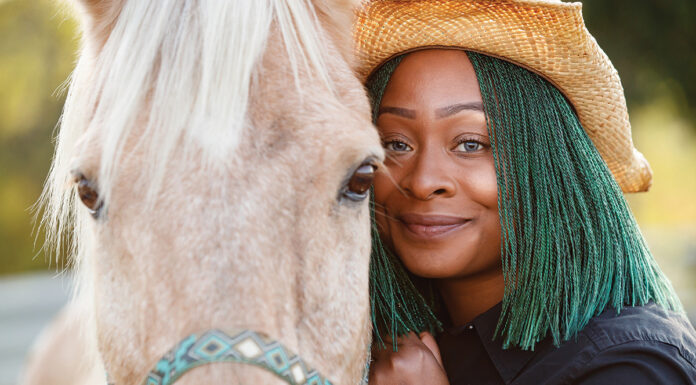 A woman at Angel Reins hugs a horse