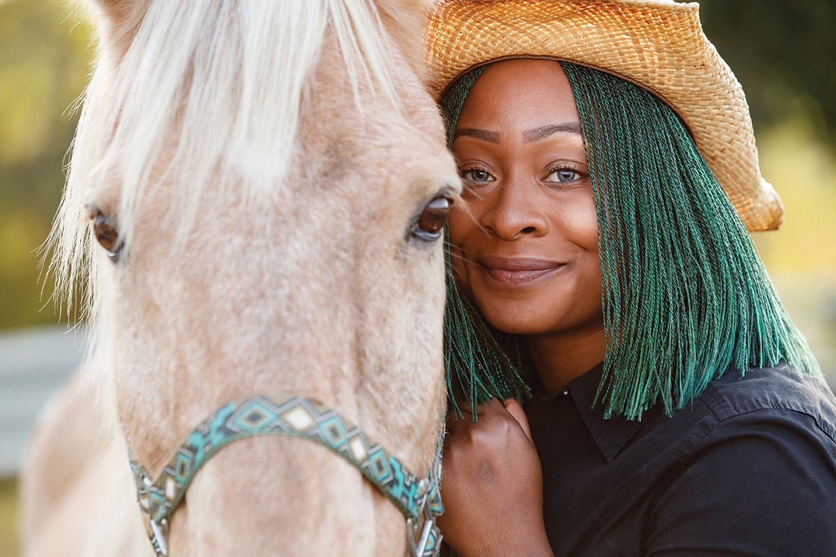 A woman at Angel Reins hugs a horse