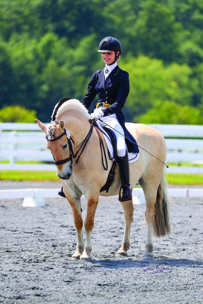 A girl competing in dressage at the Prix St. Georges level