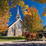 Carriage horses pass a church on Mackinac Island