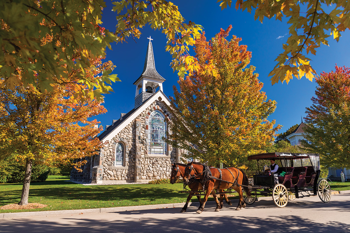 Carriage horses pass a church on Mackinac Island