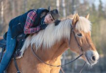 A woman hugs her old horse while riding