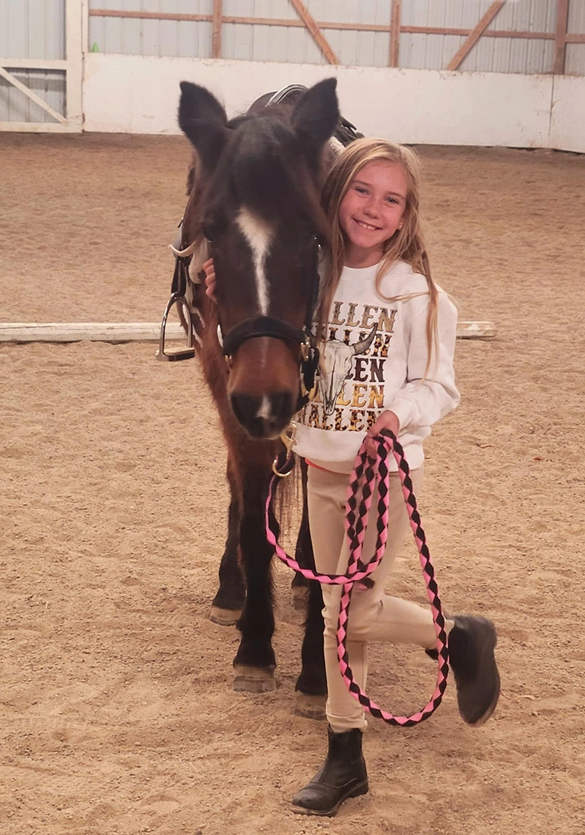 A young girl with her new horse after adopting a senior mare.