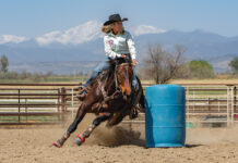 Barrel racing with mountains in the background