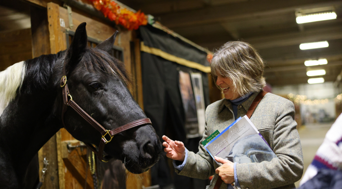 A woman greets a horse at Equine Affaire