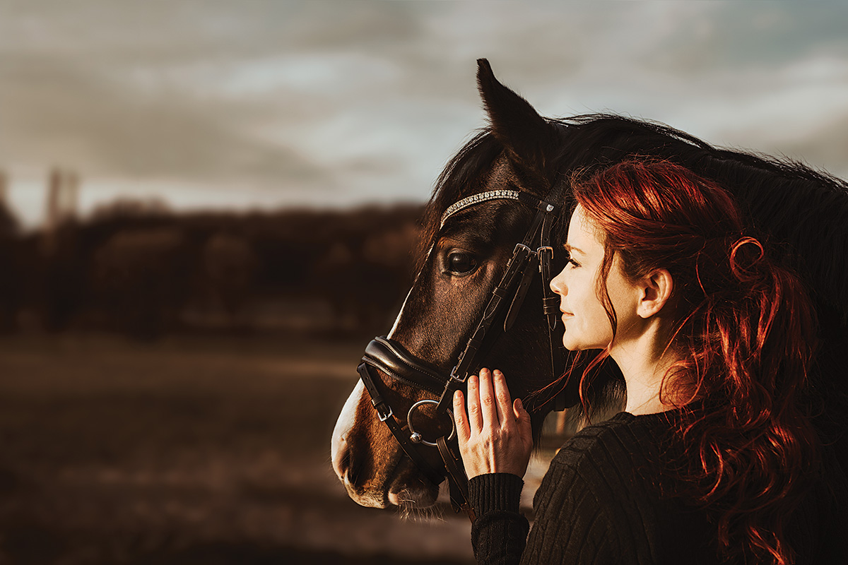 A girl hugs her horse, both displaying signs of happiness