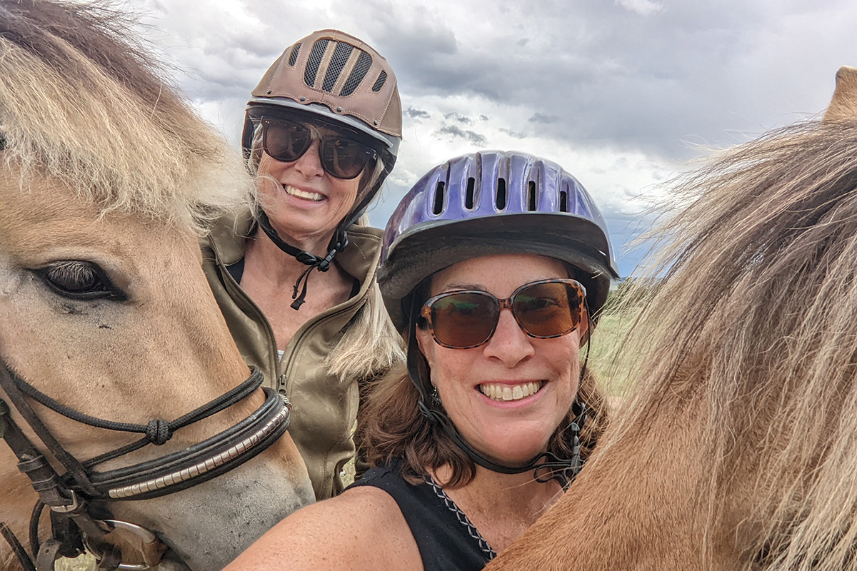 Two equestrians taking a selfie with Norwegian Fjords