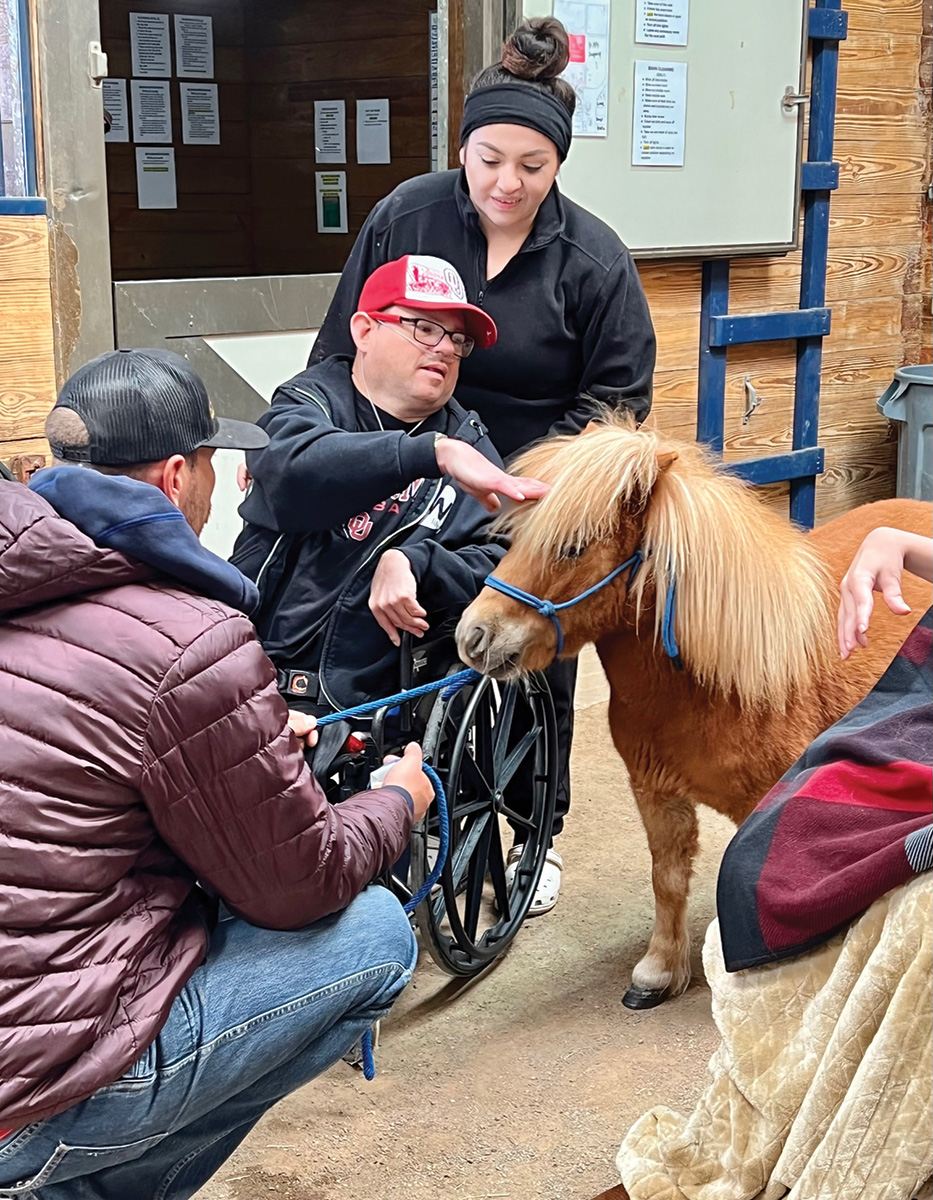 Center of Family Love members interacting with a mini horse at Nexus Equine