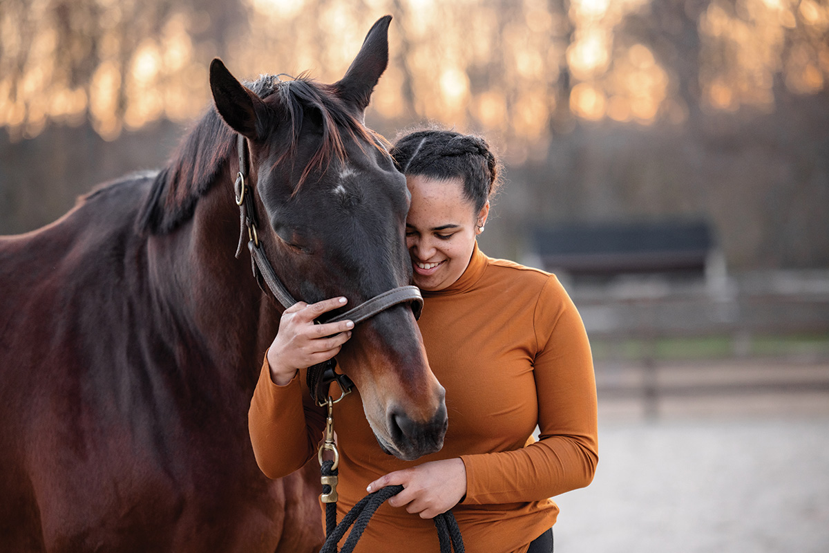 A woman hugs a retiring broodmare