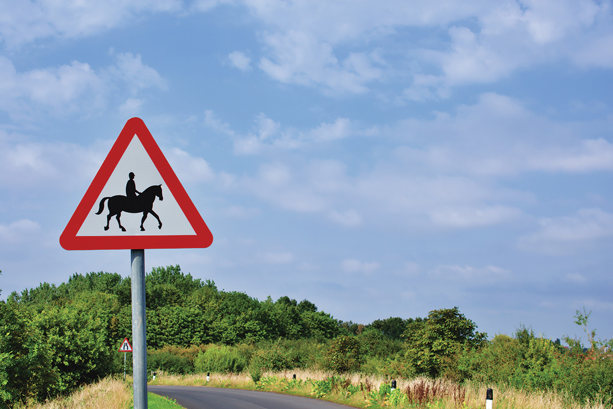 A street sign indicating an area with riders