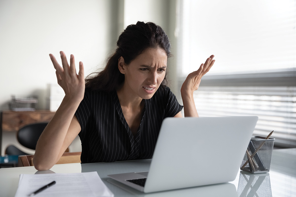 A woman reacts to a social media critic on her laptop