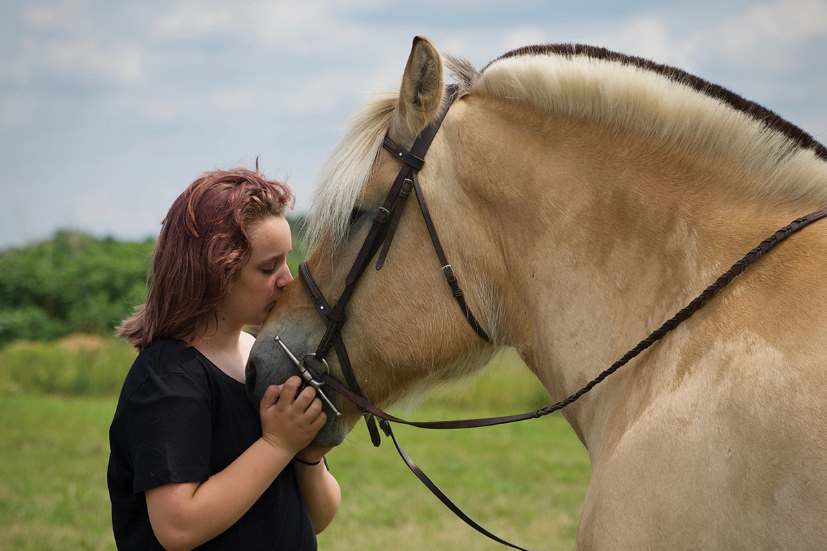 Astrid the Norwegian Fjord being kissed by her owner, who she found a new home with despite being hard-to-adopt