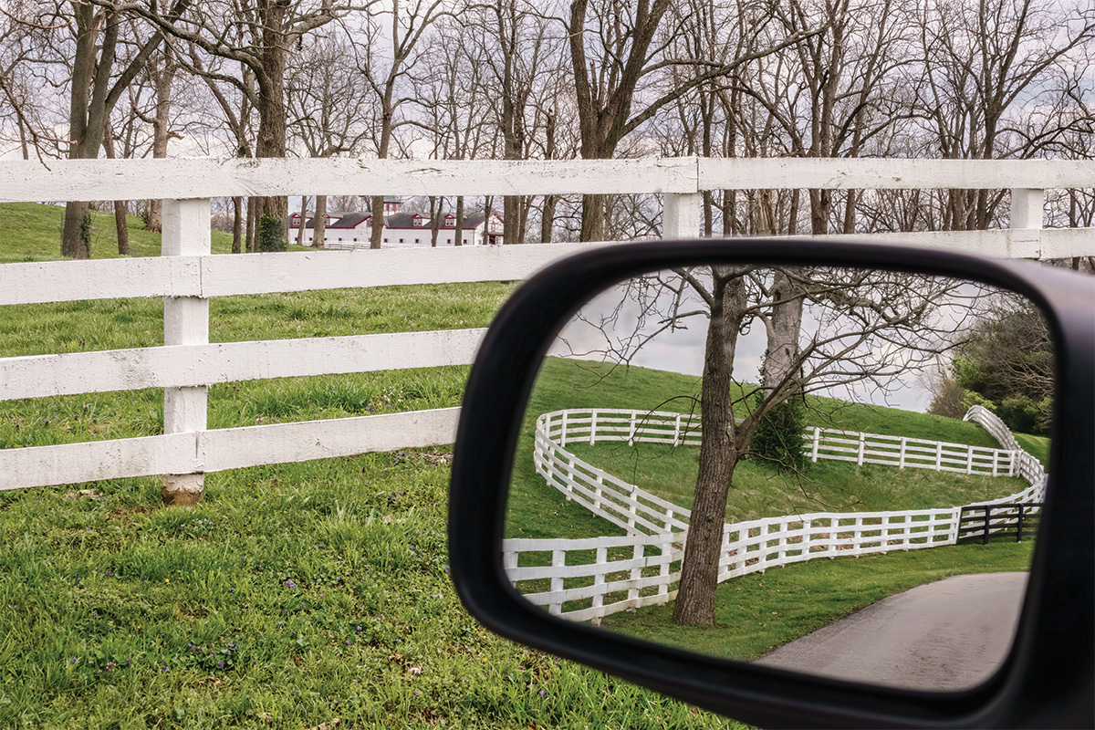 A fence line both in front of a car and shown in a rearview mirror, which has lessons to teach