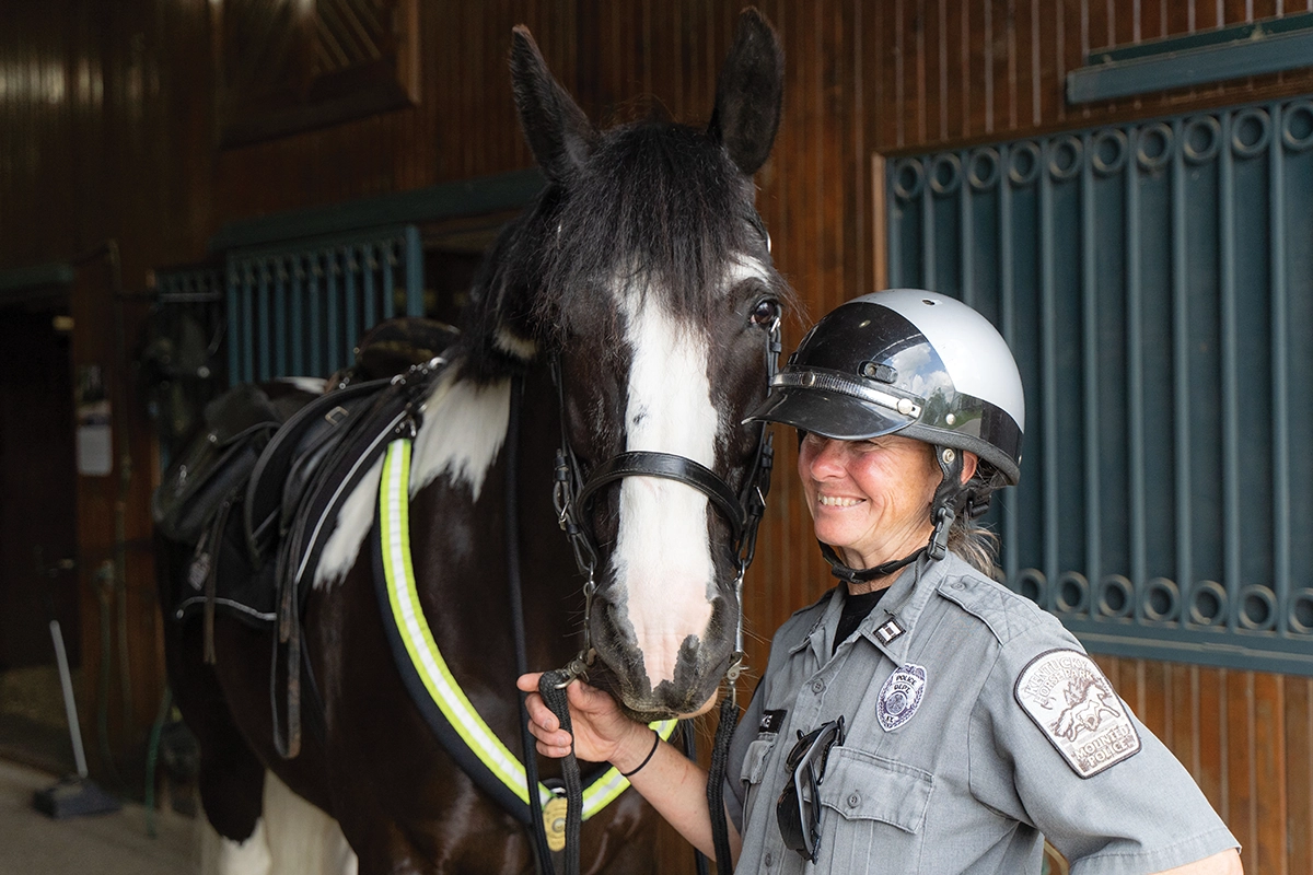 Captain Lisa Rakes beams with pride next to Oliver, a 17-year-old Paint/Shire cross.