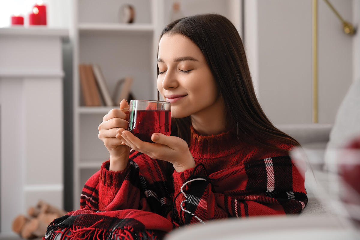 A woman enjoying a warm beverage.