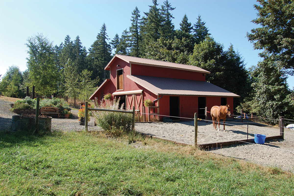 A confinement area outside of a red barn