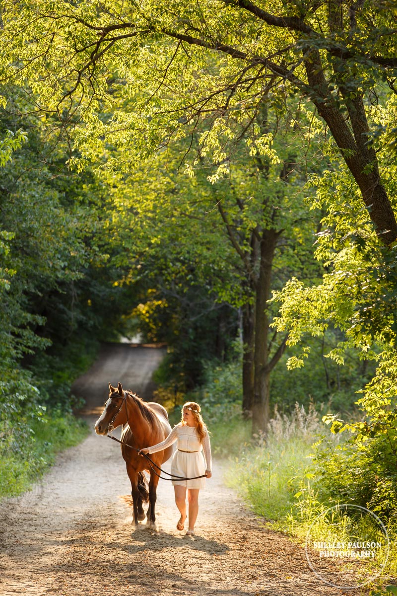 Girl walking her horse on a dirt road by Shelley Paulson