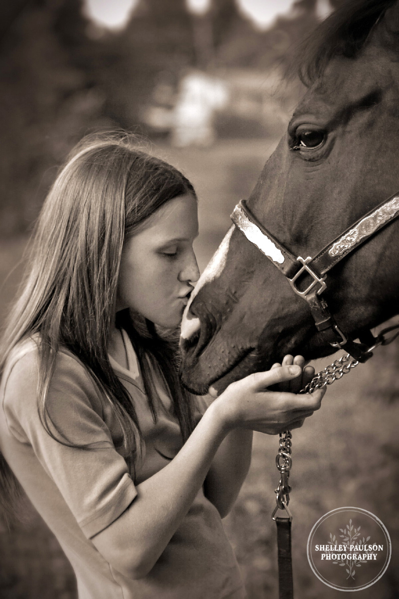 Black and white girl kissing horse by Shelley Paulson