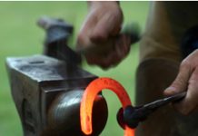 Farriers Assistance Program helps hoofcare professionals in times of need farrier shaping a hot horse shoe on an anvil