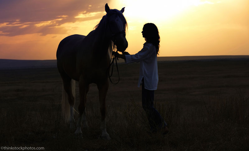 Woman and horse at sunset