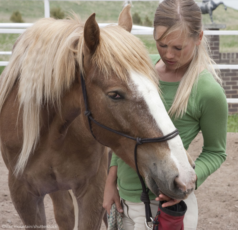 Woman feeding treats to her horse