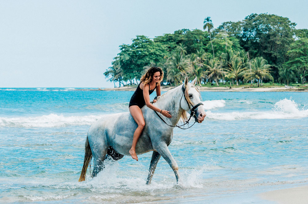 Cavaleiro em um cavalo cinza na praia de Kindred Spirits na Costa Rica