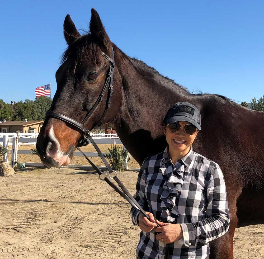 Retired bay Thoroughbred eventer Sandy Shoes with caretaker Elena