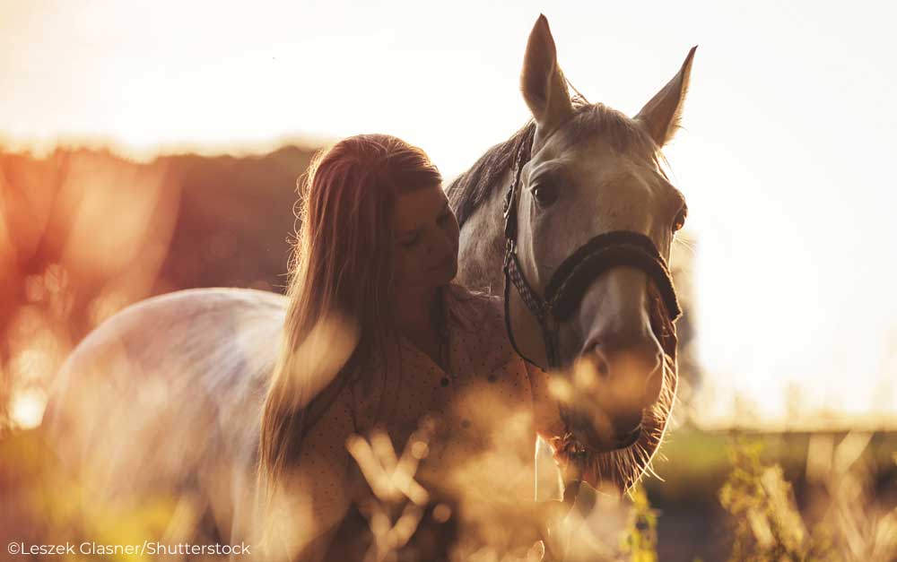 Woman with horse at sunset