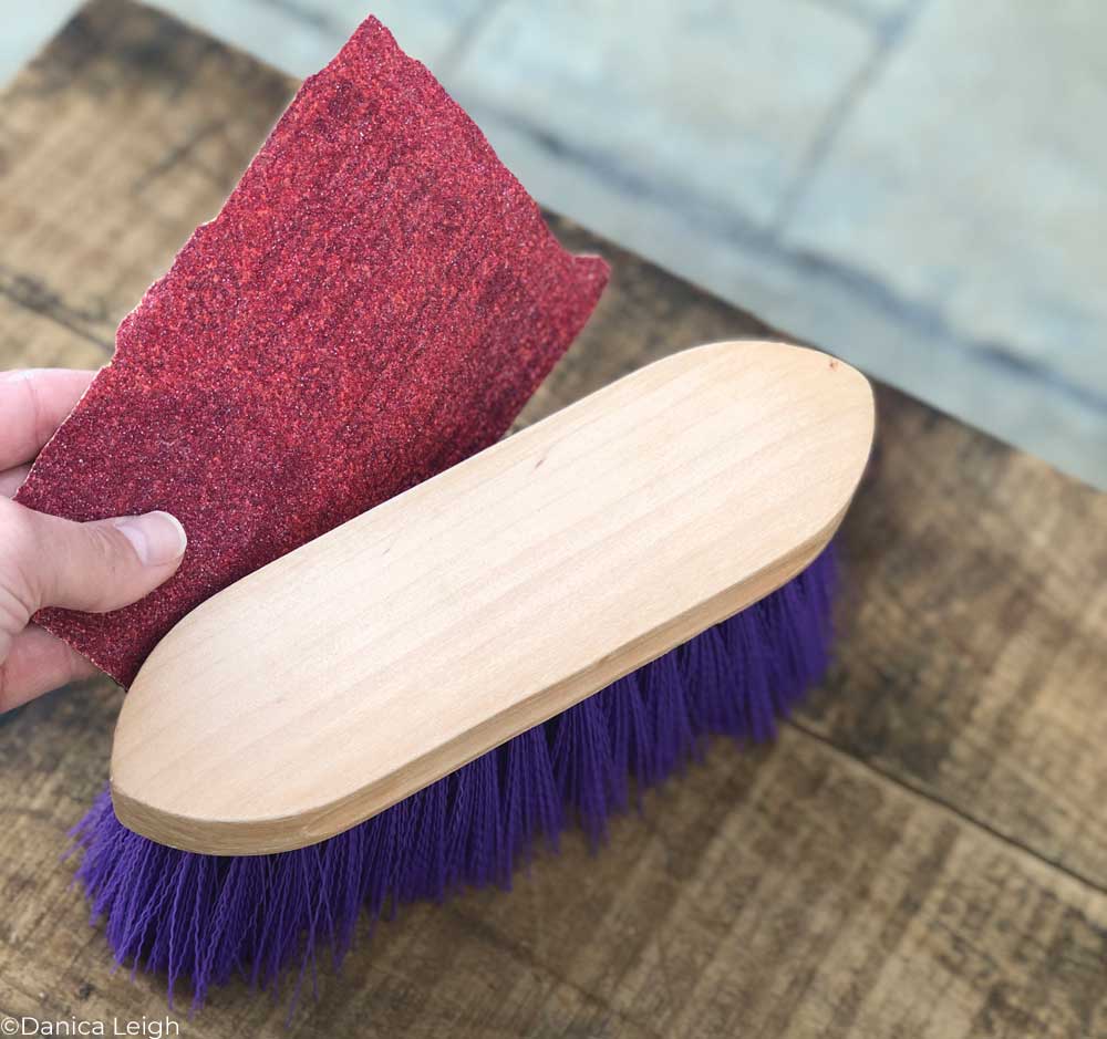 Sanding the back of a brush to prepare it for painting