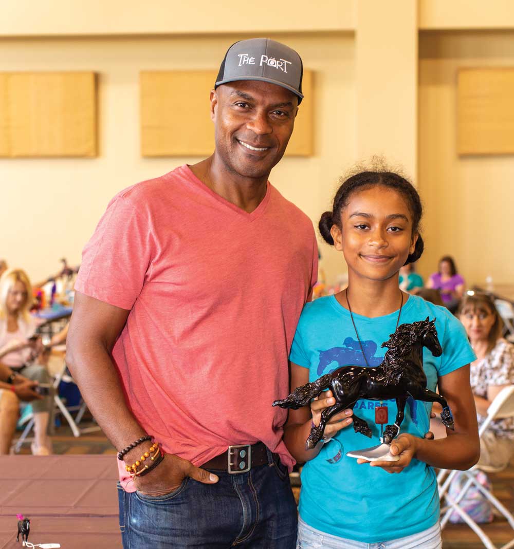 A young model horse exhibitor and her dad at a model horse show