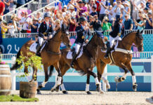 The Great Britain Eventing Team takes a victory lap around the stadium after winning gold in eventing at the 2024 Paris Olympics