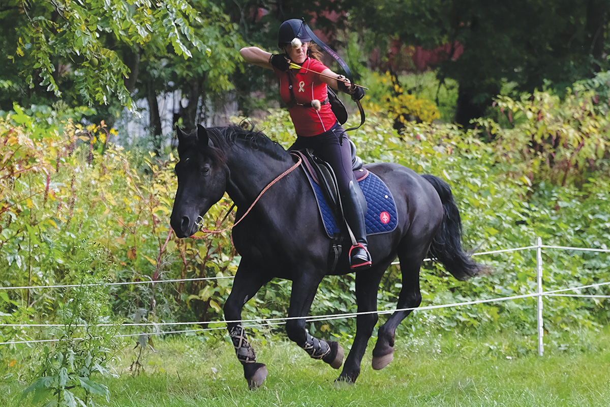 A woman performs archery aboard a Canadian Horse, an endangered equine breed
