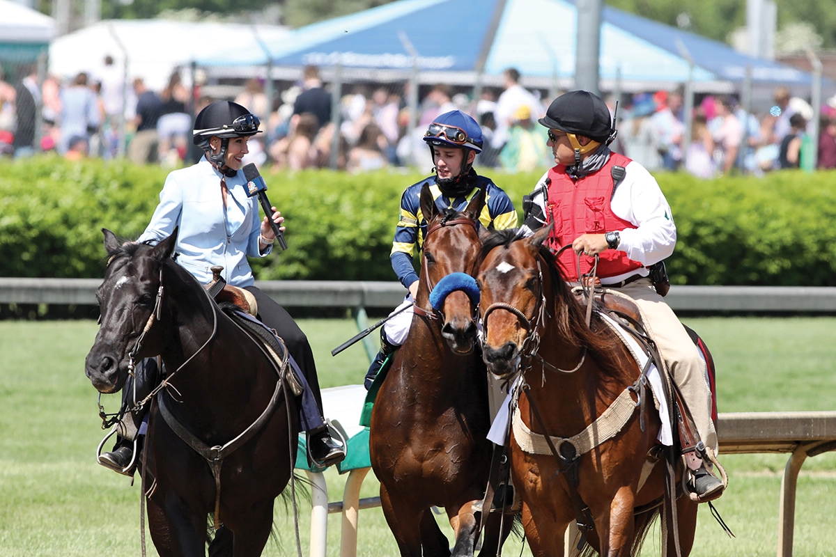 Donna Barton Brothers interviewing the winning jockey after a race.