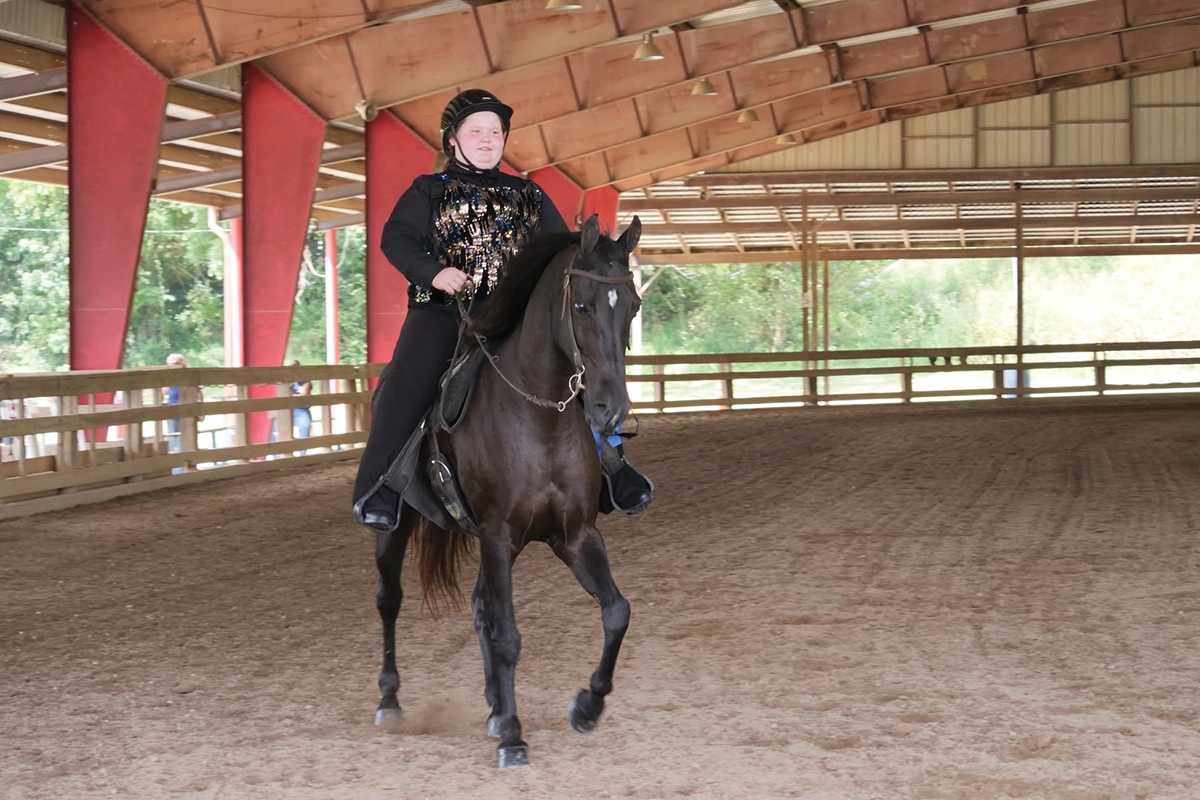 Cariana Christen cantering a horse.