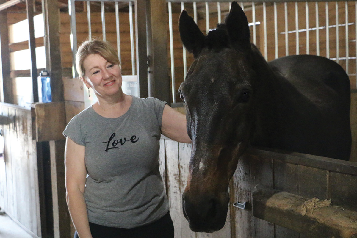 An equine sanctuary team member with a horse surrendered via an equine safety net program