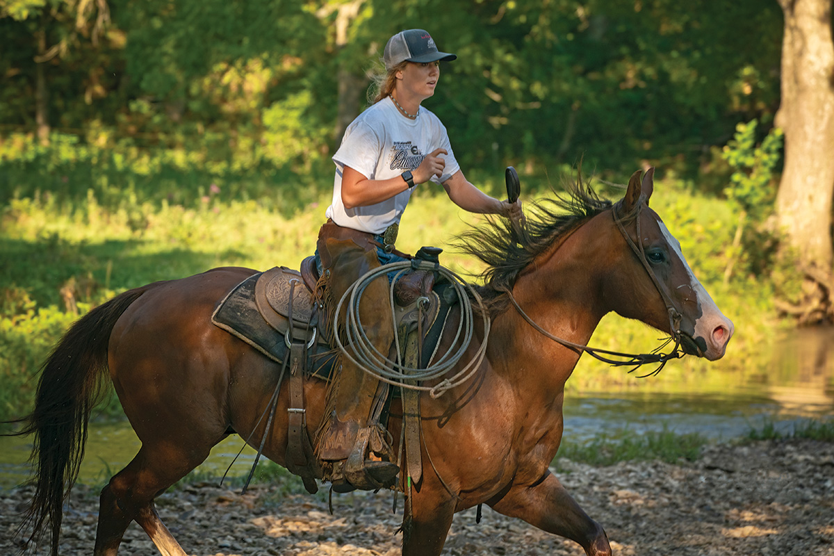 A cowgirl loping her horse