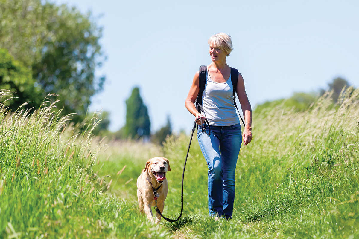 A woman walking her dog. Awareness walks can help improve your riding.