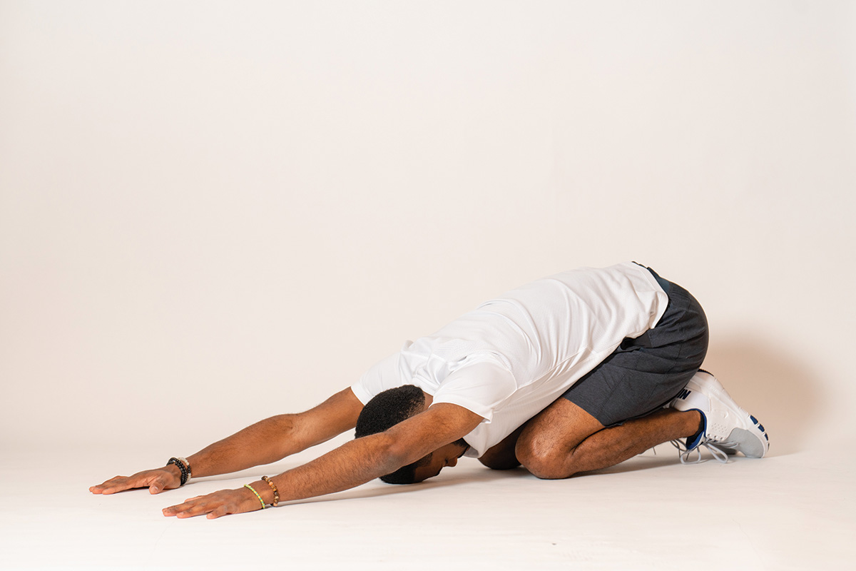 The author demonstrates child’s pose, which helps prevent rider back pain.