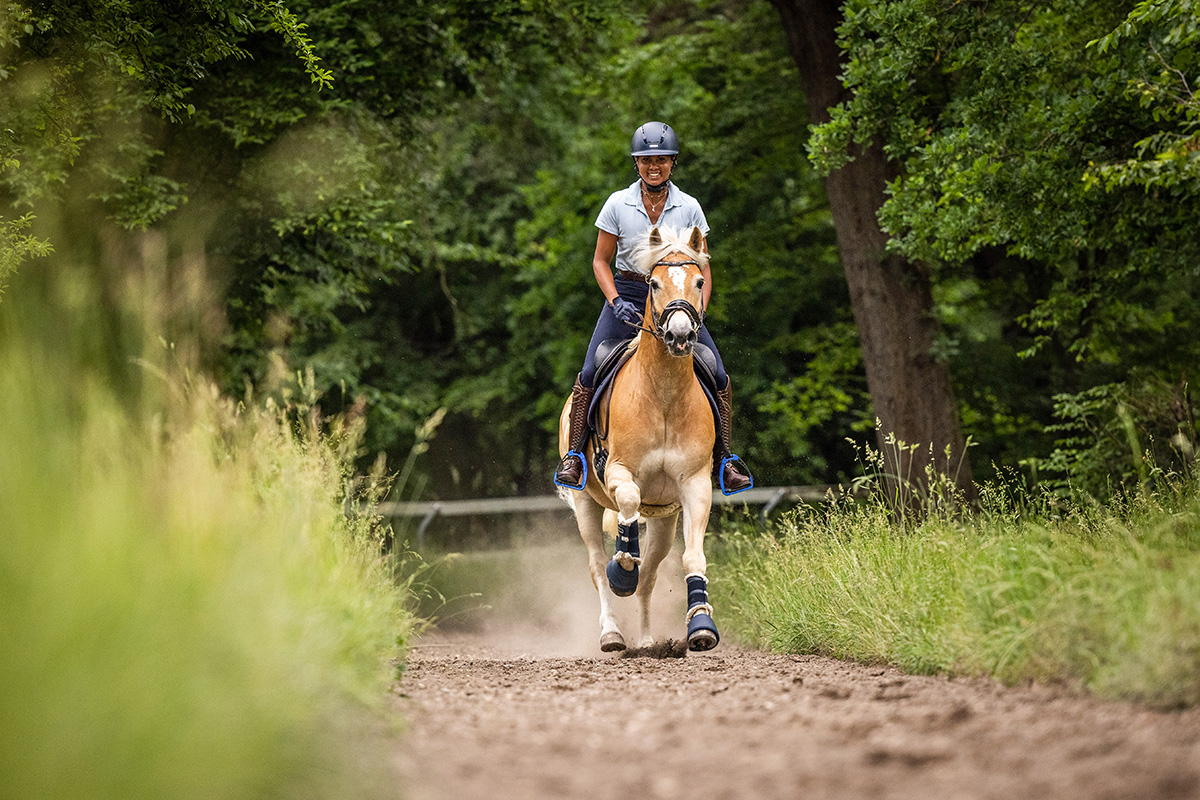 A rider choosing happiness over riding anxiety by smiling while galloping