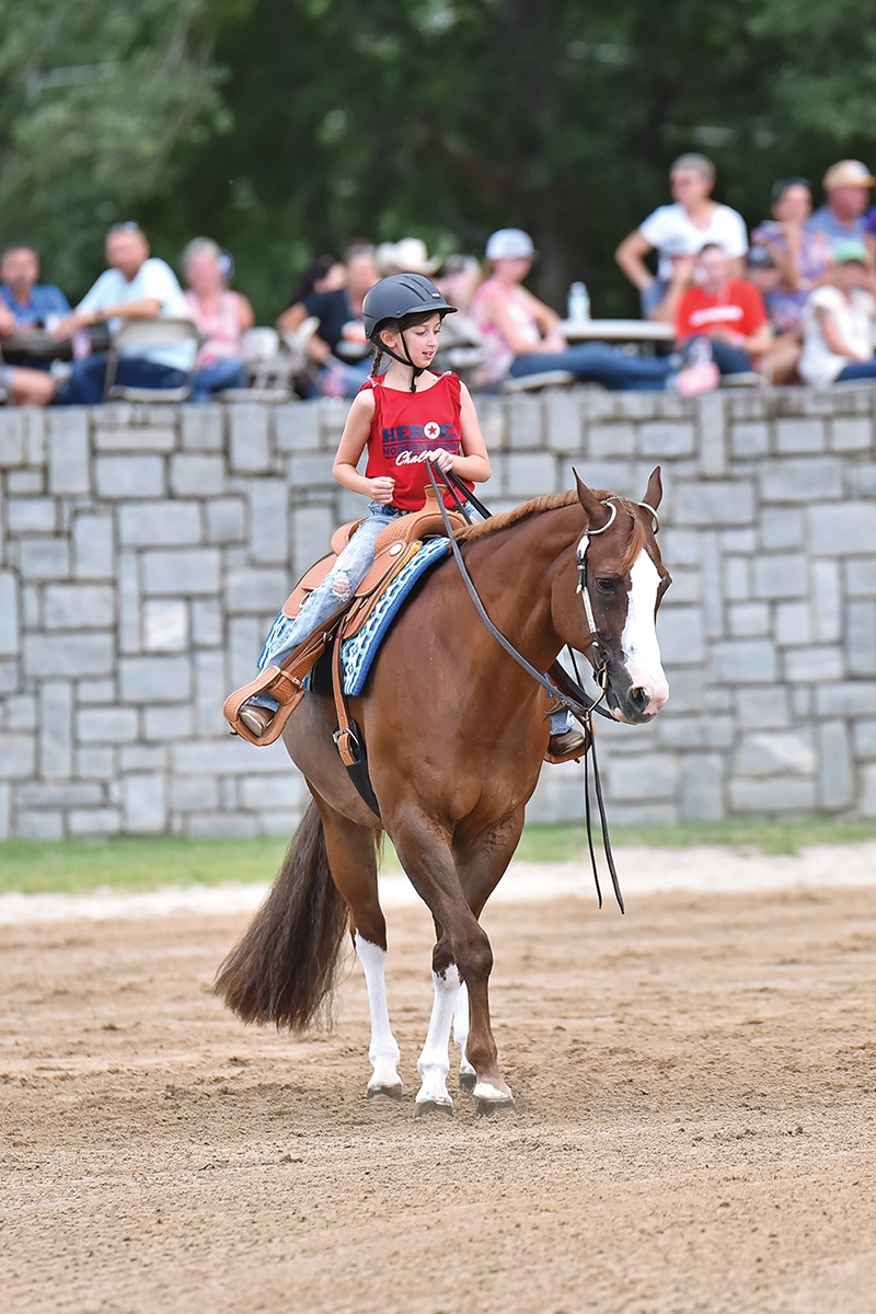 A young girl competes on a sorrel Quarter Horse.