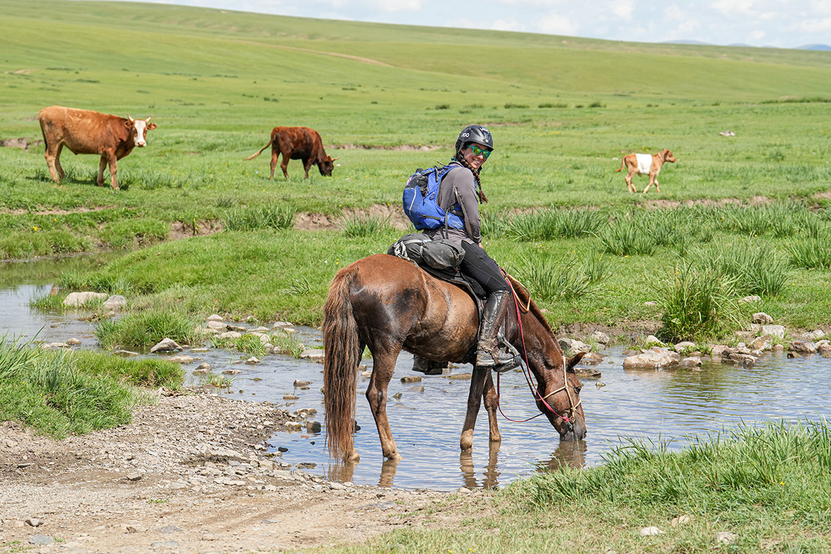 Jessie Dowling lets her horse stop for a drink during the Mongol Derby.