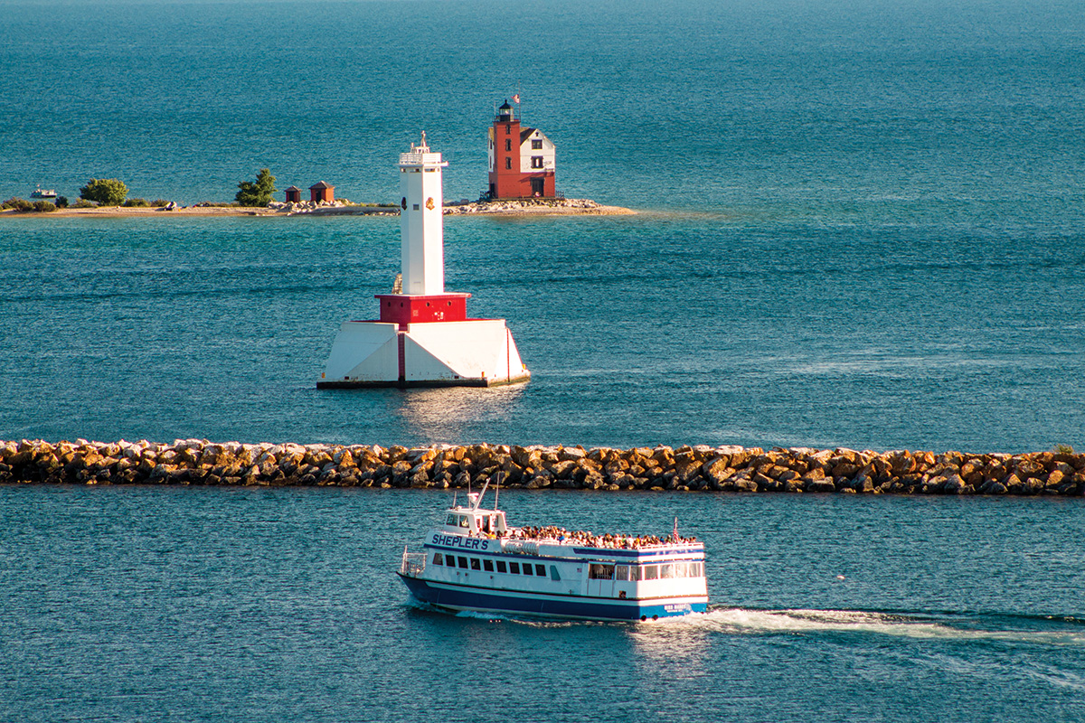 A ferry boat passes a lighthouse