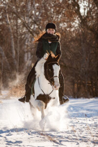An equestrian riding through the snow