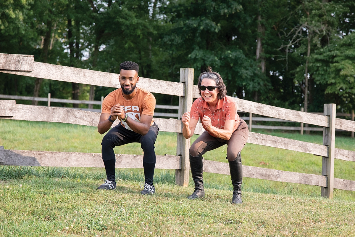 A personal trainer training squats with a senior equestrian.