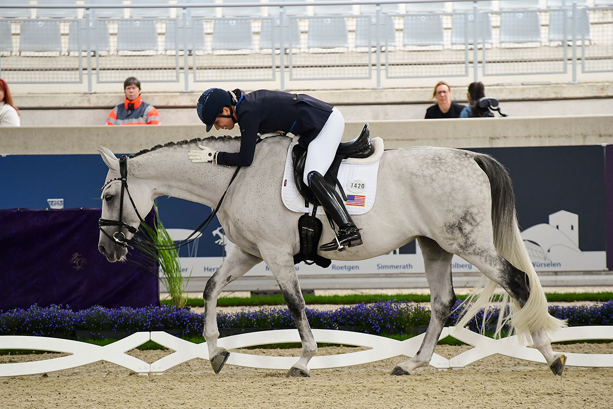 Kate Shoemaker thanks her mare Vianne after a gold-medal performance at the 2026 FEI World Championships in Aachen.