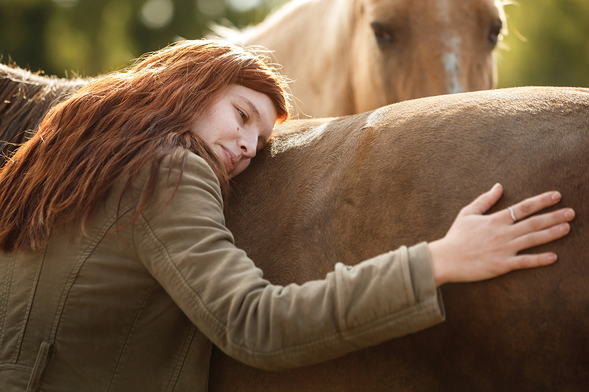 A healing victim of human trafficking hugs a horse at Angel Reins